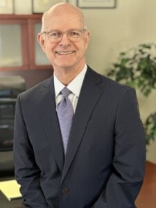 Photo of Brian Champion in a dark suit in a law office